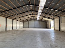 Loods van ca. 850 m² met voorliggende verharde koer/parking.