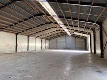 Loods van ca. 850 m² met voorliggende verharde koer/parking.