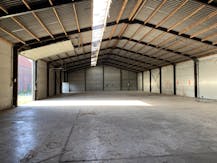 Loods van ca. 850 m² met voorliggende verharde koer/parking.