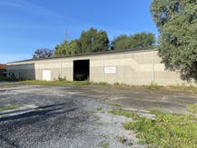 Loods van ca. 850 m² met voorliggende verharde koer/parking.